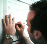 my brother signing a geocache log at the Alton Federal Prison memorial